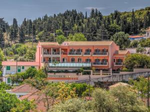 a building on a hill with trees at Fiscardo Bay Hotel in Fiskardo