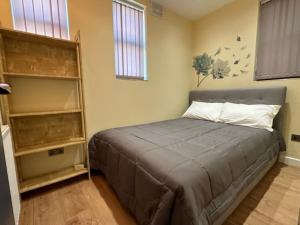 1 dormitorio con cama y estante para libros en Lovely apartment near Gatwick airport en Reigate