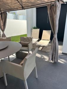 a patio with chairs and a table and a table and chairs at Luxury Villa LAGUNA - Ciudad Quesada in Ciudad Quesada