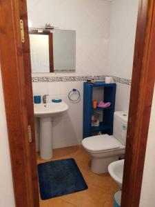 een badkamer met een wastafel, een toilet en een spiegel bij La puesta del sol in Briech