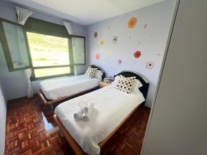- une chambre avec 2 lits et une fenêtre dans l'établissement VILLA CARMEN. coqueto apartamento con piscina y garaje, à Ezcaray