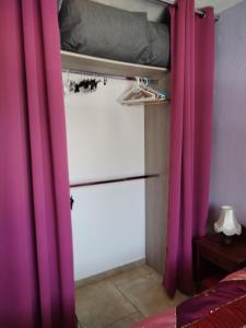 a room with pink curtains and a bed and a bed at Villa près des remparts in Régusse