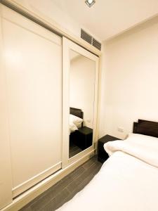 a bedroom with a large mirror and two beds at central apartment for rent 27 in Umm Uthainah
