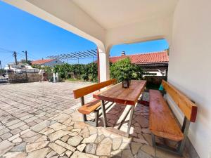 a wooden table and two benches on a patio at Apartmani Ana in Dramalj