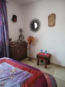 1 dormitorio con cama, mesa y espejo en Villa près des remparts en Régusse
