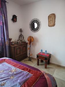 a bedroom with a bed and a table and a mirror at Villa près des remparts in Régusse