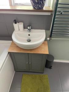 een badkamer met een witte wastafel en een spiegel bij Newmarket Cosy Stay in Newmarket