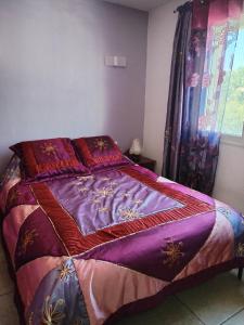 sypialnia z łóżkiem z fioletową pościelą i oknem w obiekcie Villa près des remparts w mieście Régusse
