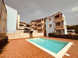 a swimming pool in front of a apartment building at Mare Blue in Badesi