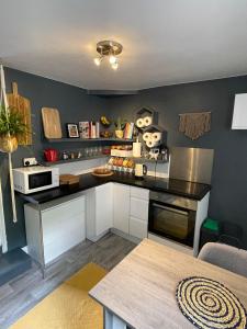 a kitchen with white cabinets and a black counter top at Newmarket Cosy Stay in Newmarket