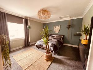 een slaapkamer met een bed en een potplant bij Newmarket Cosy Stay in Newmarket