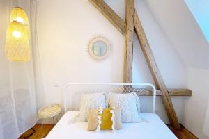 a white bed with pillows on it in a room at Zentrale 1-Zimmer-Ferienwohnung mit digitalem Check in in Hof