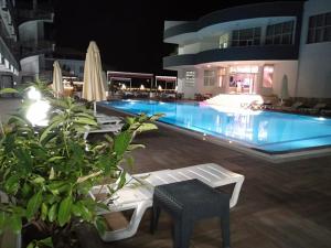 a swimming pool at night with a table and chairs at ANYA RESORT HOTEL in Pamukkale
