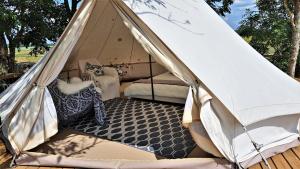 une tente avec un lit et un tapis dans l'établissement Ohukotsu Glamping, 