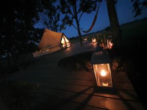 a tent with a light on a sidewalk at night at Ohukotsu Glamping in Ohukotsu