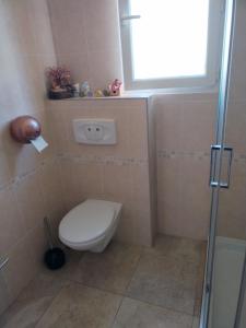 a bathroom with a toilet and a window at Villa près des remparts in Régusse