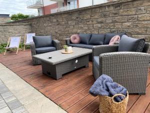a patio with two couches and a coffee table at Apartament Rewal Klifowa Morska 3 z basenem in Rewal