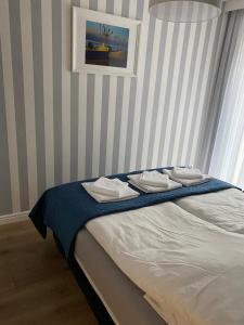 a bedroom with a bed with towels on it at Apartament Rewal Klifowa Morska 3 z basenem in Rewal