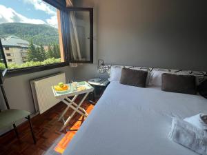 a bedroom with a large bed and a table with a window at VILLA CARMEN. coqueto apartamento con piscina y garaje in Ezcaray