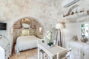 a bedroom with a bed and a stone wall at Ostuni Dimore Aurea in Ostuni