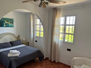 um quarto com uma cama e uma ventoinha de tecto em El Camison Apartment em Playa de las Americas