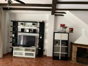 uma sala de estar com televisão e lareira em El Camison Apartment em Playa de las Americas