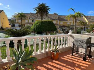 a balcony with a white fence and palm trees at El Camison Apartment in Playa de las Americas