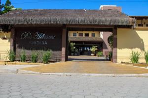 un bâtiment avec toit de chaume et patio dans l'établissement Pousada dos Hibiscus, à Ilhéus