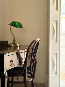 een bureau met een groene lamp en een stoel bij L'Artist Casa Micallef in Valletta
