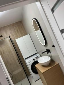 a bathroom with a sink and a washing machine at Apartament Nowoczesny w Centrum Torunia/podziemny parking i winda in Toruń +5 photos