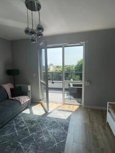 a living room with a couch and a large sliding glass door at Apartament Nowoczesny w Centrum Torunia/podziemny parking i winda in Toruń