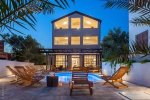 a villa with a swimming pool and rocking chairs at Amazing Villa Grande with swimming pool in Sveti Petar