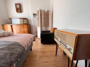 a bedroom with a dresser and a bed and a chair at Apartament Harmony in Dębogórze