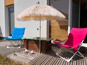 two chairs and a table and an umbrella on a deck at Apartament Harmony in Dębogórze