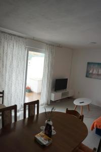a living room with a table and a television at Apartments Lučin in Drvenik Veli