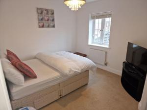 a small bedroom with a bed and a television at NightRest Homes 6 Bedroom House- Smart TV In each Room - Parking - Wifi -Milton Keynes in Milton Keynes
