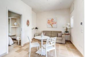 a living room with a table and chairs and a couch at Ostuni Dimore Aurea in Ostuni