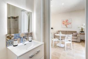 a bathroom with a sink and a living room at Ostuni Dimore Aurea in Ostuni