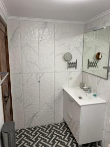 a white bathroom with a sink and a shower at El Camison Apartment in Playa de las Americas