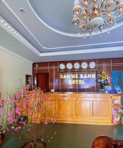 a lobby with a bar with flowers and a chandelier at Khách sạn Ban Mê Xanh (Ban Me Xanh Hotel) in Buon Ma Thuot