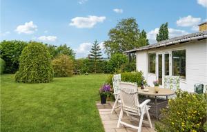 d'une terrasse avec 2 chaises et une table dans la cour. dans l'établissement Cozy Home In Bogense With Wifi, à Bogense