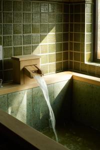 vasca da bagno con acqua che esce da un rubinetto di Slow House Niseko a Niseko