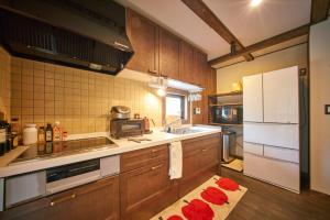 a kitchen with wooden cabinets and a white refrigerator at Slow House Niseko in Niseko