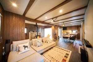 a living room with a couch and a dining room at Slow House Niseko in Niseko