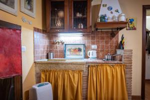 cocina con encimera con cortinas amarillas en Santa Fiora Ospitalità Diffusa - Il Nido, en Santa Fiora