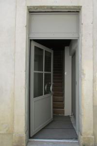 - l'entrée d'un bâtiment avec une porte et des escaliers dans l'établissement Appartement climatisé au cœur des remparts, à Die