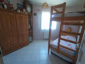 ein Schlafzimmer mit einem Etagenbett und einer Leiter in der Unterkunft Charmante Dépendance in Caussade