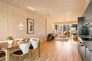 uma cozinha e sala de estar com uma mesa de madeira e cadeiras em 7,3sq mts room -Forests cozy house em Stavanger