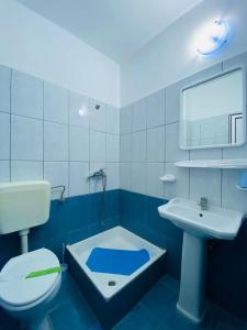 un bagno bianco e blu con servizi igienici e lavandino di PIERRE 3 la Tarmul MARII -primim Vouchere Vacanta a Costinesti