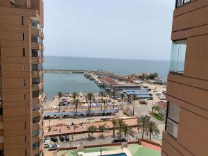 vistas a una playa con palmeras y un puerto en Torre 2 planta 11, en Fuengirola